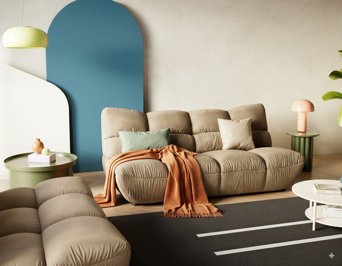 Modernes Wohnzimmer mit beigen Sofas, einem orangefarbenen Überwurf, grünen Tischen und bunten Deko-Akzenten.