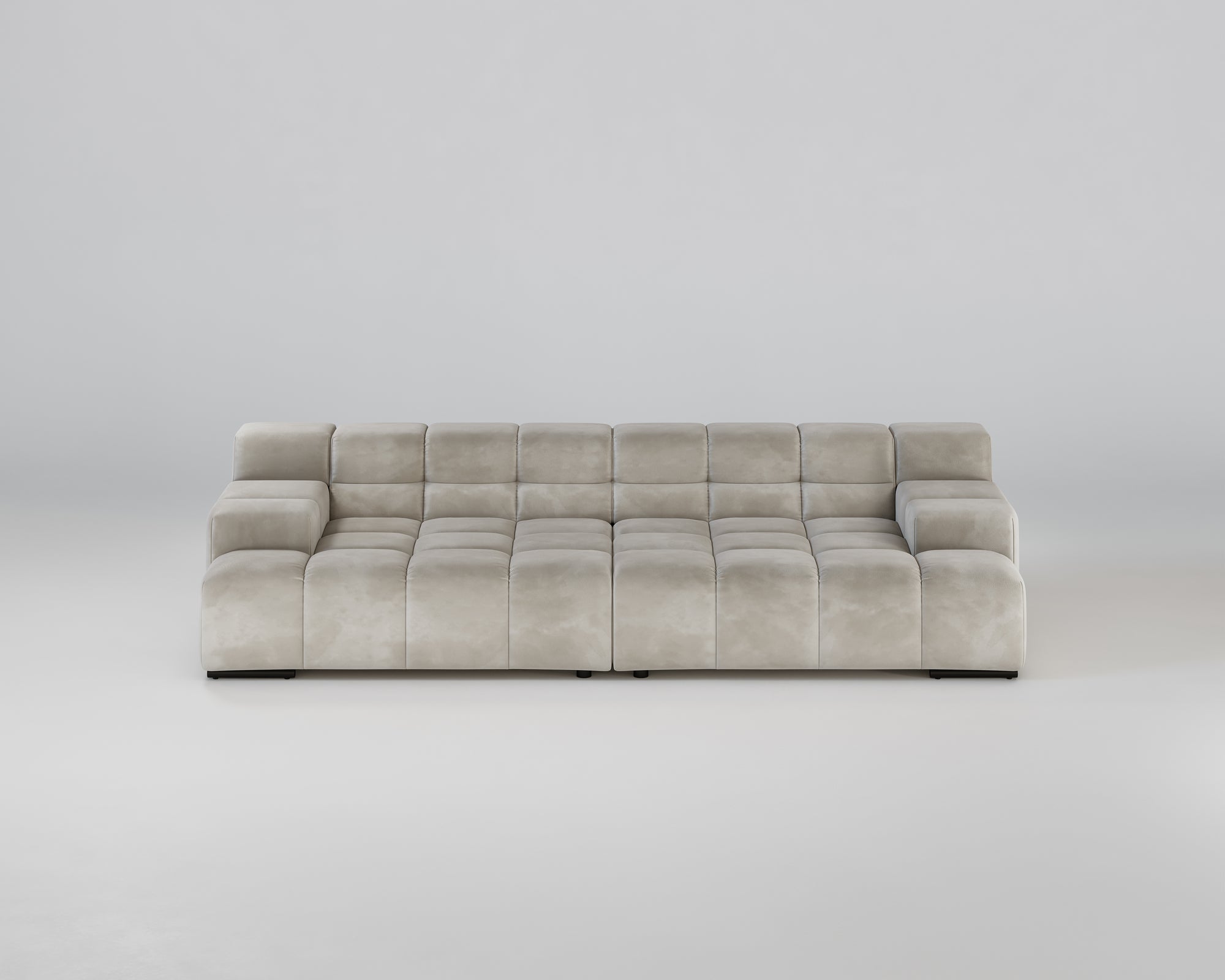 Ein modernes, hellgraues, getuftetes Sofa mit breiten Armlehnen und einer niedrigen Rückenlehne auf einem schlichten weißen Hintergrund.
