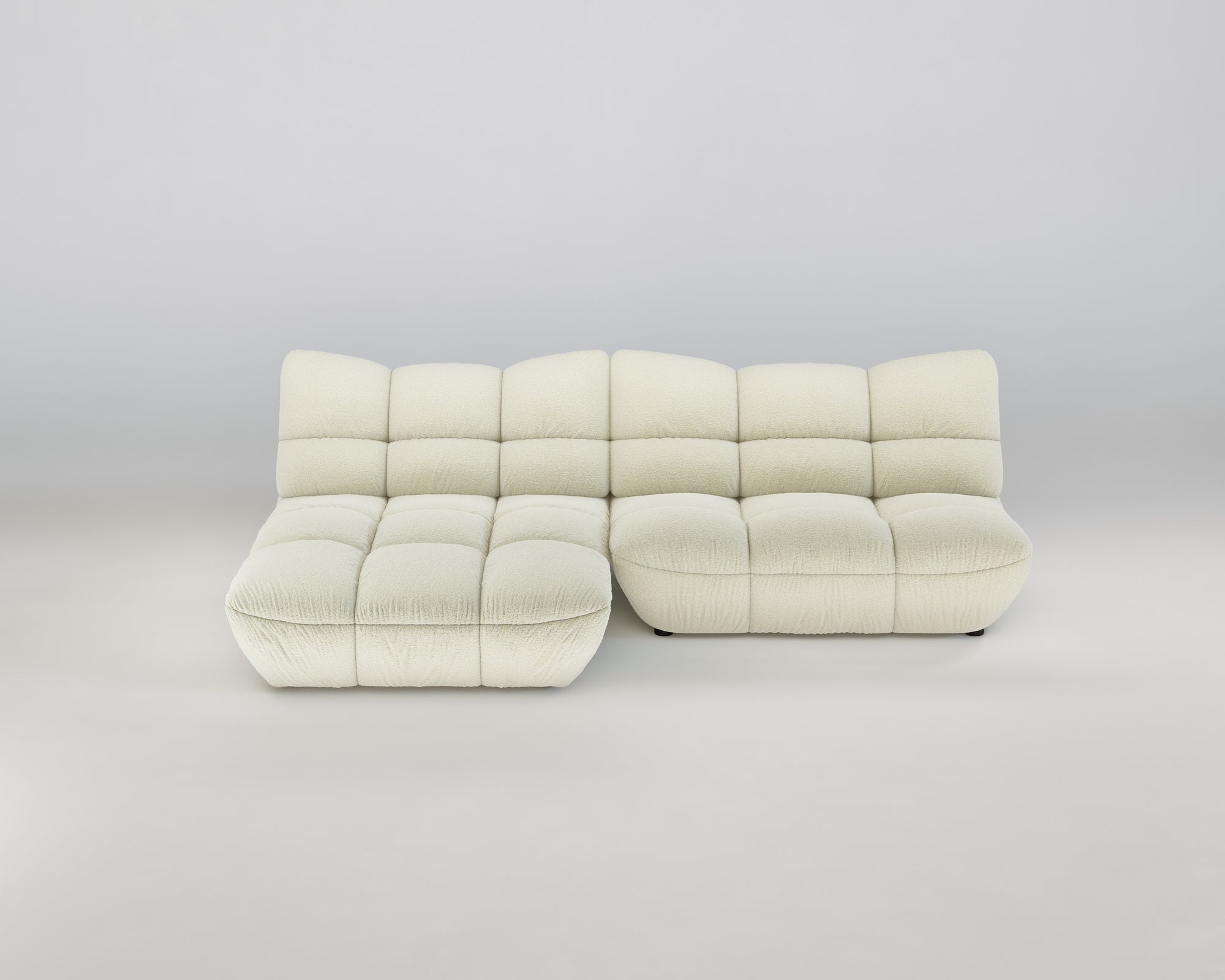 Cremefarbenes Pomodoro XL Ecksofa (Links) mit getufteten Kissen und tiefer Sitzfläche auf hellem Grund.